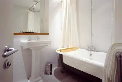 a white bathroom with a sink and a tub and a sink at The Racquet Club in Liverpool