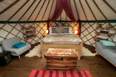 a room with a bed and a table in a yurt at Little Oakhurst in Clitheroe