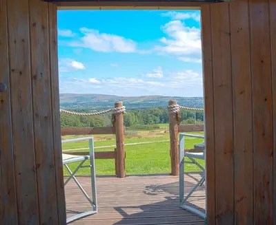 a porch with two chairs and a view of the mountains at Little Oakhurst in Clitheroe