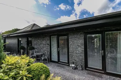 a brick house with black windows and a patio at Willow Lodge Hambleton in Poulton le Fylde