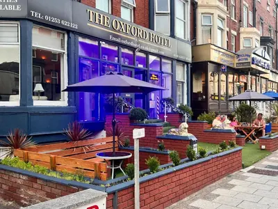 a restaurant with a bench and an umbrella in front of it at The oxford Hotel in Blackpool