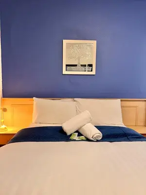 a bedroom with a bed with a blue wall at The oxford Hotel in Blackpool