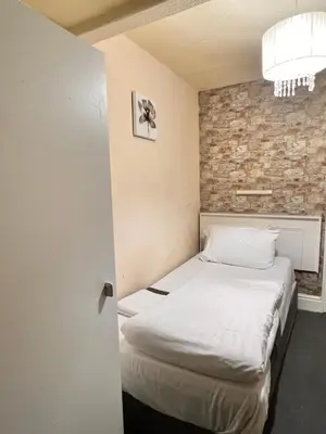 a bed in a room with a brick wall at The oxford Hotel in Blackpool