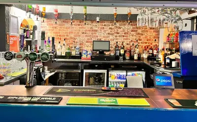 a bar with a counter in a bar with a bartender at The oxford Hotel in Blackpool