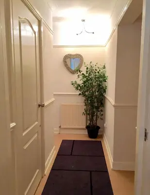 a hallway with a door and a potted plant at Be My Guest Liverpool - Ground Floor Apartment with Parking in Liverpool