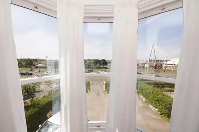 a window with white curtains and a view of a street at Grade 2 Listed Apartment, Southport Promenade in Southport