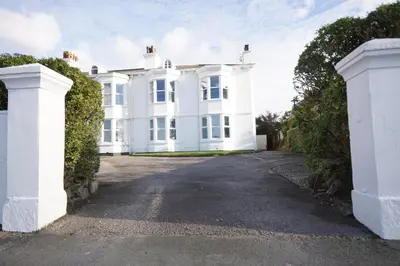 a white house with a driveway at Grade 2 Listed Apartment, Southport Promenade in Southport