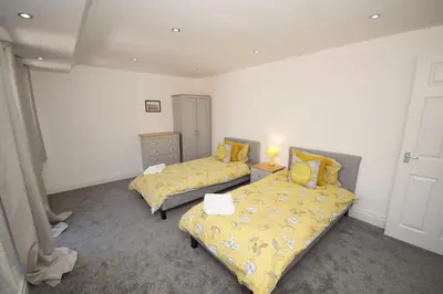 a bedroom with two beds with yellow bedspreads at Grade 2 Listed Apartment, Southport Promenade in Southport