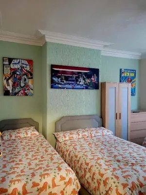 a bedroom with two beds and posters on the wall at The Clevedon in Blackpool