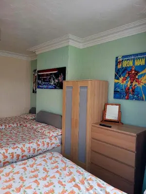 a bedroom with two beds and a desk and a picture at The Clevedon in Blackpool