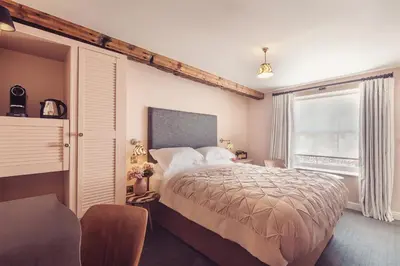 a bedroom with a large bed and a window at The New Inn in Carnforth