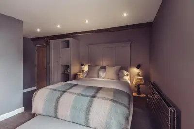 a bedroom with a large bed with a striped blanket at The New Inn in Carnforth