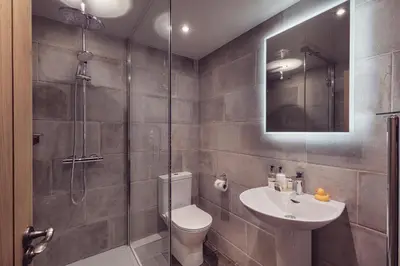 a bathroom with a shower and a toilet and a sink at The New Inn in Carnforth