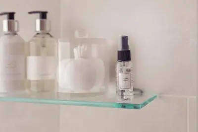 a glass shelf with bottles on it in a bathroom at The New Inn in Carnforth