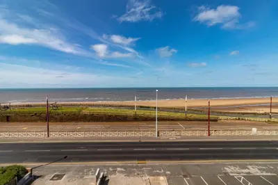a view of the beach from a parking lot at Granada Apartments Queen's Promenade in Blackpool