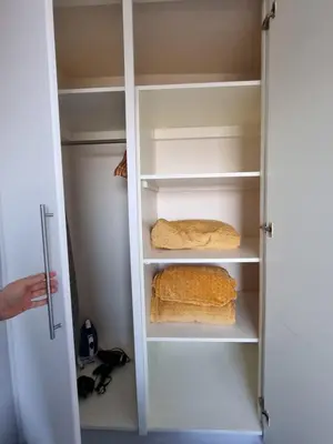 a closet with a door open with two shelves at Granada Apartments Queen's Promenade in Blackpool