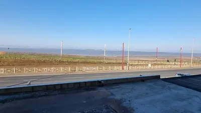 an empty road with a view of the ocean at Granada Apartments Queen's Promenade in Blackpool