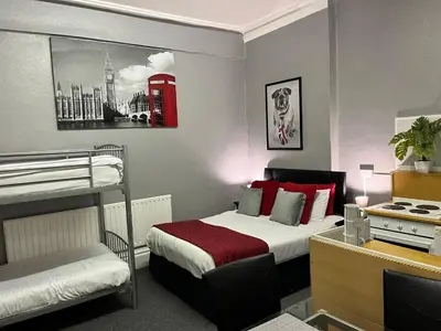 a small room with a bed and a desk and a bed sidx sidx sidx at On The Beach Apartments in Blackpool