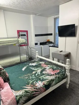 a bedroom with a bunk bed and a kitchen at On The Beach Apartments in Blackpool