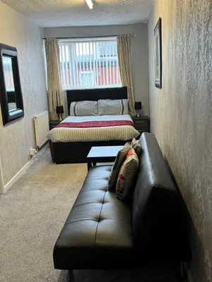 a living room with a couch and two beds at On The Beach Apartments in Blackpool