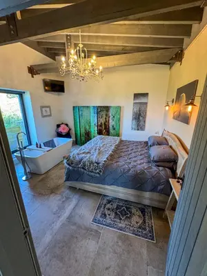 a bedroom with a bed and a chandelier at The Chicken Shed at Knowle Top in Clitheroe