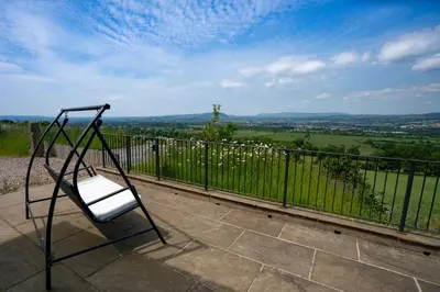 a chair on a balcony with a view of a field at The Chicken Shed at Knowle Top in Clitheroe