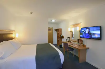 a hotel room with a bed and a desk and a tv at Lea Gate by Greene King Inns in Preston
