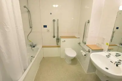 a bathroom with a toilet and a sink and a shower at The Mount by Greene King Inns in Wigan