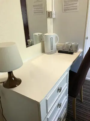 a dressing table with a lamp and a mirror at The Feathers Hotel in Blackpool