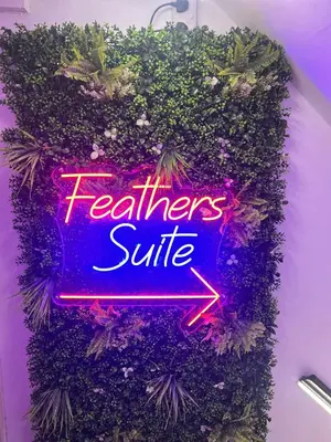 a neon sign that says teachers suite in a bush at The Feathers Hotel in Blackpool