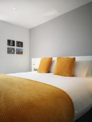 a bedroom with a large bed with yellow pillows at Mode Hotel Lytham in Lytham St Annes