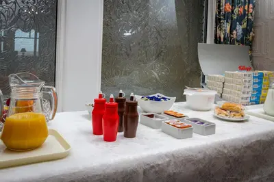 a table with ketchup bottles and other food items on it at Maples Hotel in Blackpool