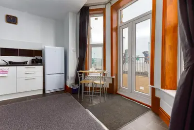 a kitchen with a refrigerator and a table next to a window at Maples Hotel in Blackpool