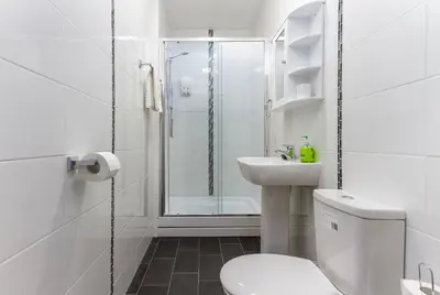 a bathroom with a shower and a toilet and a sink at Maples Hotel in Blackpool