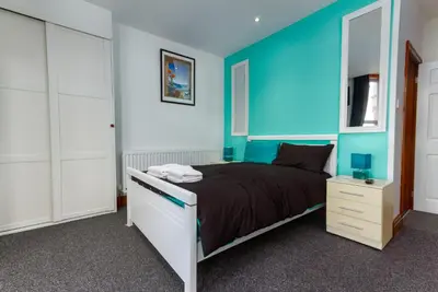a bedroom with a bed and a blue wall at Maples Hotel in Blackpool