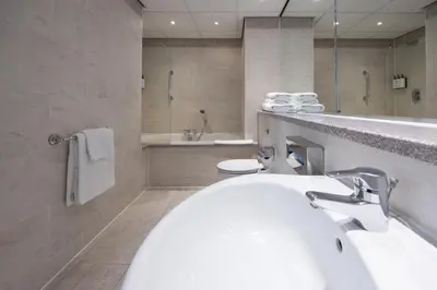 a bathroom with two sinks and a bath tub at Crowne Plaza Liverpool City Centre by IHG in Liverpool