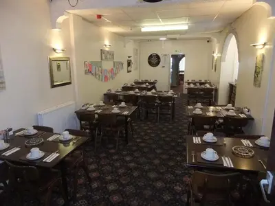 a dining room with wooden tables and chairs at Charnley Gold in Blackpool