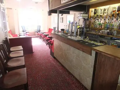 a bar with a row of stools in a restaurant at Charnley Gold in Blackpool