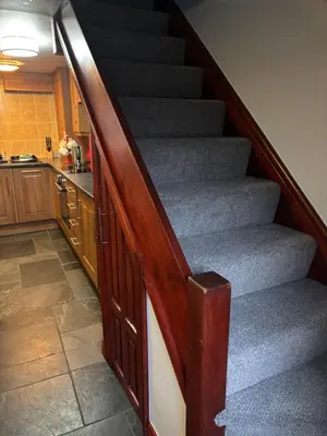 a staircase in a house with a kitchen and a kitchen at Causeway Cottage in Cartmel