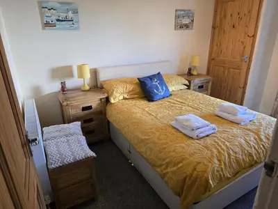 a bedroom with a bed with two towels on it at Eden Rose Cottage hot-tub jacuzzi morecambe-bay in Morecambe