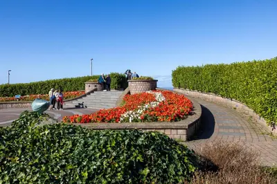 a garden with red and white flowers in a park at Eden Rose Cottage hot-tub jacuzzi morecambe-bay in Morecambe