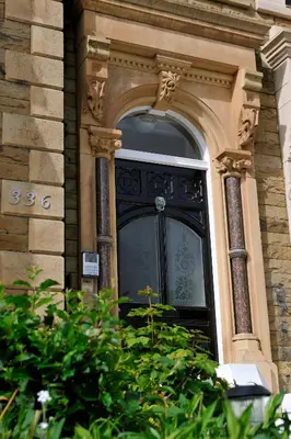 a large black door on a building with plants at Hy Lytham St Anne's in Lytham St Annes