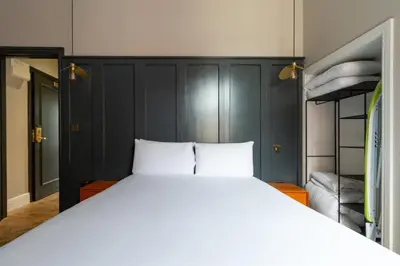 a bedroom with a large white bed and bunk beds at Hy Lytham St Anne's in Lytham St Annes