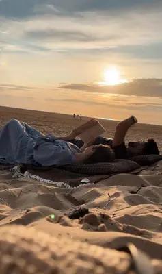 two people laying on the beach reading a book at Hy Lytham St Anne's in Lytham St Annes