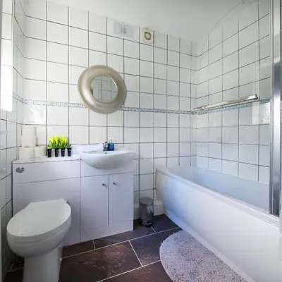 a bathroom with a tub and a toilet and a sink at Stylish and Comfortable Home Away From Home in Liverpool
