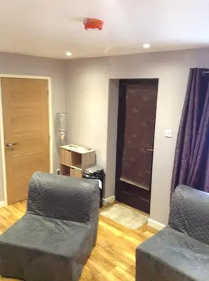 a living room with two chairs and a window at The Anfield Apartment in Liverpool