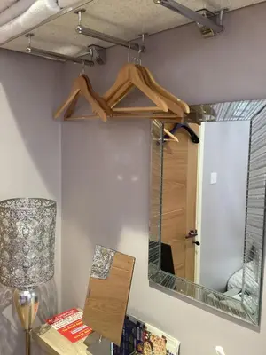 a mirror on a wall next to a table with a lamp at The Anfield Apartment in Liverpool