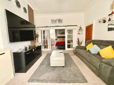 a living room with a couch and a flat screen tv at Victoria House - Self Catering Quiet Guesthouse - Adult Singles and Couples Only in Blackpool