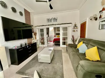 a living room with a green couch and a flat screen tv at Victoria House - Self Catering Quiet Guesthouse - Adult Singles and Couples Only in Blackpool