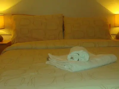 a bed with a pile of towels on it at Wilsons Hotel - Blackpool Tower View in Blackpool